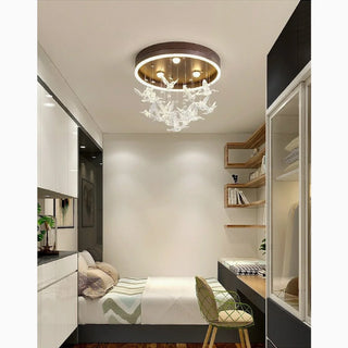 Alabaster flush mount ceiling light glowing above a bed in a low-ceiling bedroom