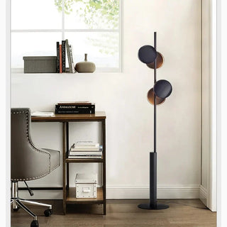 Modern floor lamp providing ambient lighting in a cozy home office reading corner