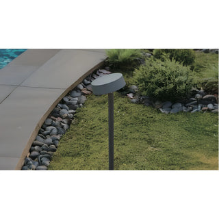 Garden path light beside a stone walkway with a gravel border