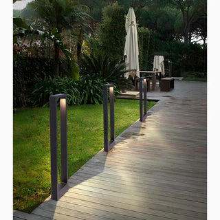 Warm bollard path lights spaced along a wooden garden walkway beside a lawn at dusk by Mirodemi