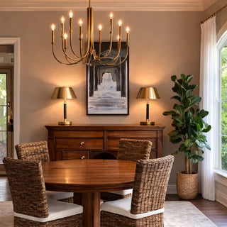Retro brass candle-style chandelier over a dining table with wicker chairs