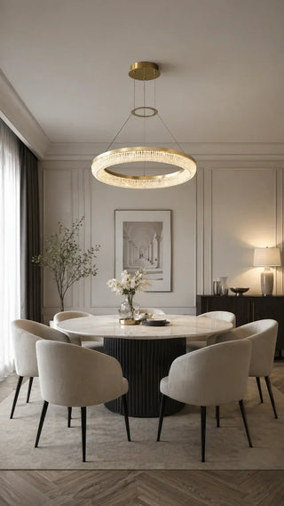 Round gold drum chandelier hanging over a modern round dining table