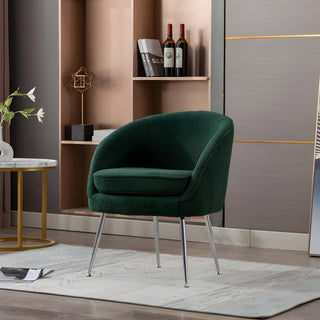 Green velvet accent chair with chrome legs in a styled living room corner