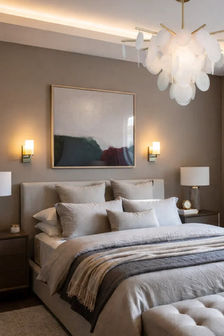 Layered bedroom lighting with a statement chandelier, wall sconces, and a bedside lamp