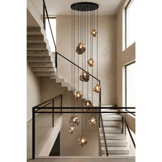 Cluster of pendant lights drop-hung above a multi-story staircase