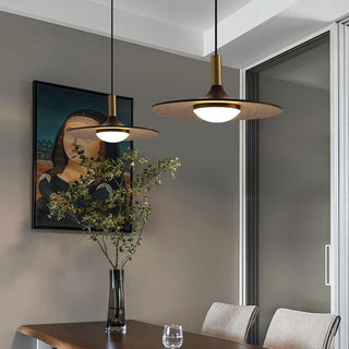 Two walnut and brass mid-century pendant lights hanging over a dining table