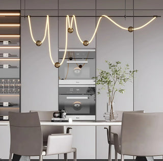 Linear pendant light fixture hanging over a kitchen counter