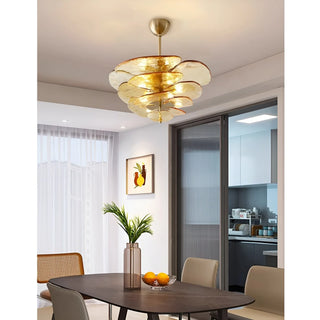 Layered amber glass disc chandelier hanging in a dining room