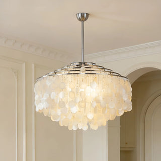 Silver capiz shell chandelier hanging in a modern living room with warm ambient lighting