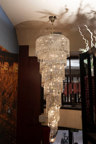 Tall two-story foyer crystal chandelier by Mirodemi cascading down a high entryway