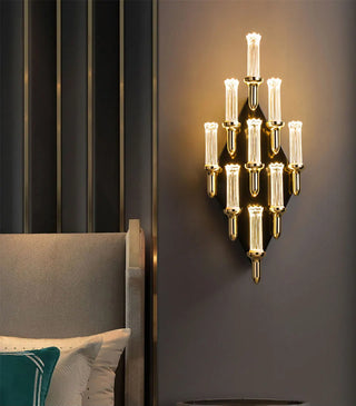 Gold candle-shaped wall lamp with a graceful curved arm