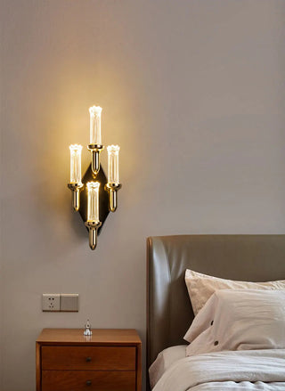 Candle-shaped gold wall sconce for a hallway