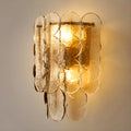Close-up of amber glass wall light sconce, showcasing the elegant design and warm glow from the light inside