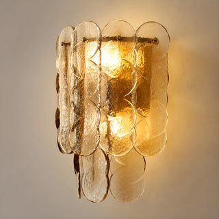 Close-up of amber glass wall light sconce, showcasing the elegant design and warm glow from the light inside