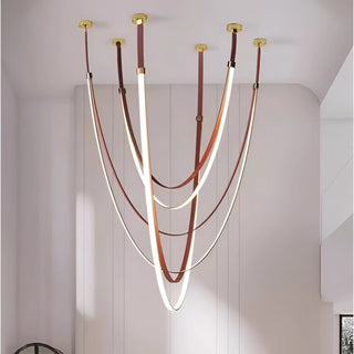 Aurelia leather pendant light featuring soft LED illumination and elegant curved straps in brown and gold, perfect for modern interiors