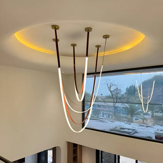 Minimalist LED chandelier from the Aurelia collection with smooth curved leather loops and marble-wood contrast interior