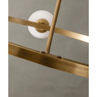 Detailed shot of the brass chandelier’s frame and one of its spherical white glass elements