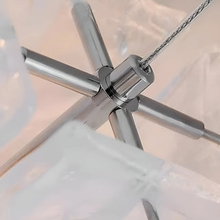 Close-up of chandelier metal frame connection with polished chrome finish and suspension cables
