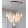 Close view of modern chandelier with layered glass shades and warm LED bulbs hanging from ceiling mount