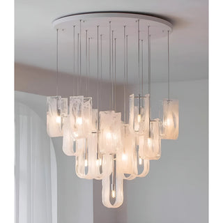 Close view of modern chandelier with layered glass shades and warm LED bulbs hanging from ceiling mount