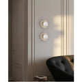 Living room with two natural stone wall sconces, each with a frosted glass globe, placed on either side of a sofa for balanced lighting