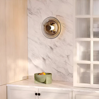 Contemporary glass wall sconce installed on white marble wall in modern kitchen