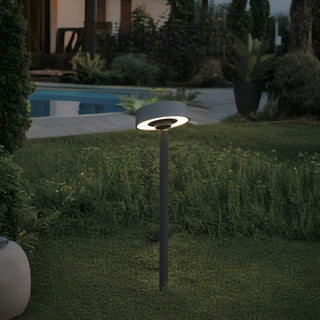 Modern garden light glowing warmly at night, highlighting landscape textures and adding ambiance