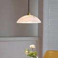 Lunara alabaster pendant light softly lighting a modern table with floral décor in a warm minimalist space