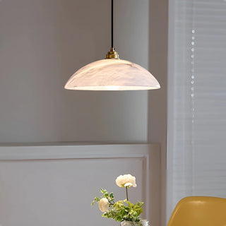 Lunara alabaster pendant light softly lighting a modern table with floral décor in a warm minimalist space