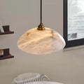 Lunara alabaster pendant hanging near a window, showing unique cloudy texture of Spanish alabaster