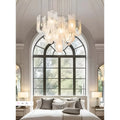 Contemporary chandelier with multiple frosted glass shades suspended from a round ceiling plate in a bright room