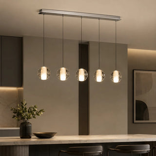 Five-light linear Lenno crystal bubble-glass globe pendants above a marble kitchen island