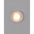 Natural stone wall light with a white glass globe, featured in a minimalist interior, adding a touch of sophistication to the design