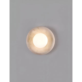 Natural stone wall light with a white glass globe, featured in a minimalist interior, adding a touch of sophistication to the design