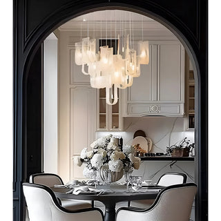 Stylish chandelier with multiple glass shades illuminating a contemporary kitchen and dining area