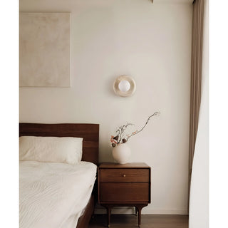Stylish bedroom with a natural stone wall sconce featuring a white glass globe, adding a soft, ambient light to the room's decor