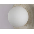 Close-up of a natural stone wall sconce with a white frosted glass globe, highlighting the sleek design and texture of the stone