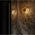 Amber glass wall sconce installed on marble accent wall with soft ambient glow.