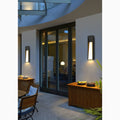 LED wall lights casting warm light near a patio area with furniture, plants, and large glass doors.
