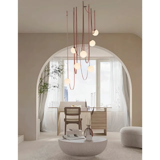 Elegant Scandinavian leather and glass chandelier hanging in an arched contemporary room with soft daylight