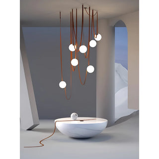 Contemporary Scandinavian belt chandelier with leather straps and glowing glass balls suspended above a minimalist coffee table