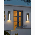 Two LED wall lamps installed symmetrically by a balcony door, casting a cozy glow on the white wall.