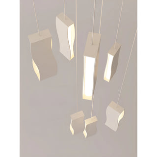 Close-up of modern wavy LED pendant lights with soft diffused glow and minimalist aluminum design