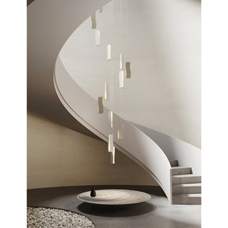 Luxury modern staircase chandelier featuring sculptural LED pendants cascading in a curved architectural stairwell.