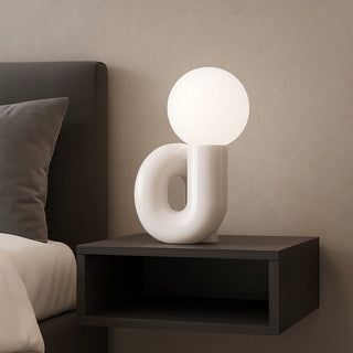 White resin sculptural lamp on nightstand beside bed – soft warm bedside light for modern bedrooms