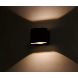 Aeris wall sconce emitting warm upward and downward light in night ambiance