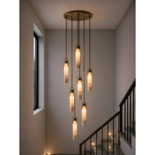 Large seven-light alabaster cluster staircase chandelier creating elegant vertical lighting in a modern stairwell.