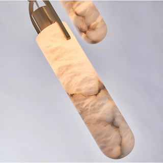 Close-up of a handcrafted natural alabaster pendant light with brushed brass hardware and warm LED illumination.