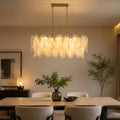 Altavilla Rectangular Murano Glass Chandelier installed over a dining table, showing glowing glass panels and room setup