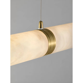 Close-up of the Alvara pendant's brushed brass ring connector and suspension cable on the alabaster tube
